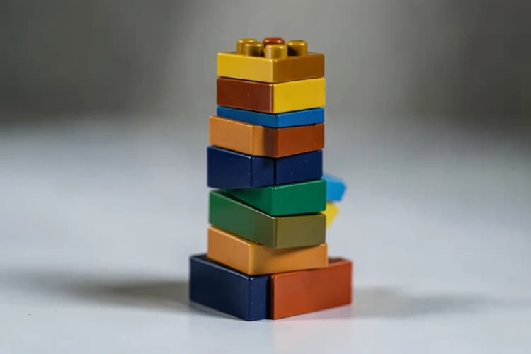 Um conjunto de blocos de construção coloridos sendo montados em uma torre, representando a implementação passo a passo da automação de vendas.