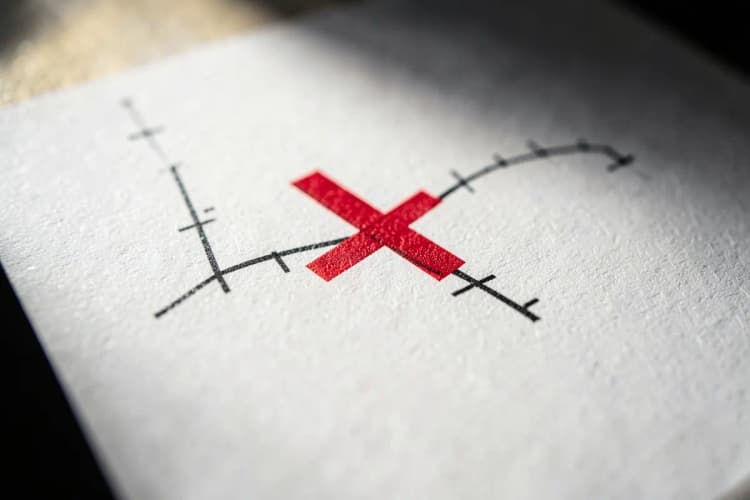 Sinal de 'X' vermelho sobre um gráfico de desempenho em declínio