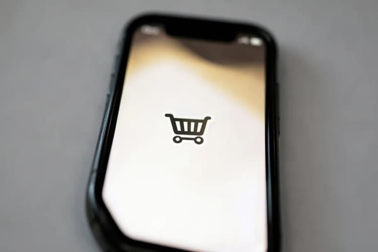 Um celular exibindo uma conversa do WhatsApp com um ícone de carrinho de compras