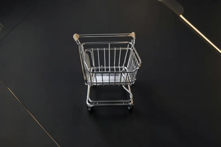 Carrinho de compras de e-commerce com setas apontando para cima indicando otimização.