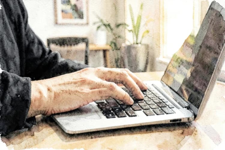 Pessoa trabalhando em um computador com gráficos de vendas na tela.